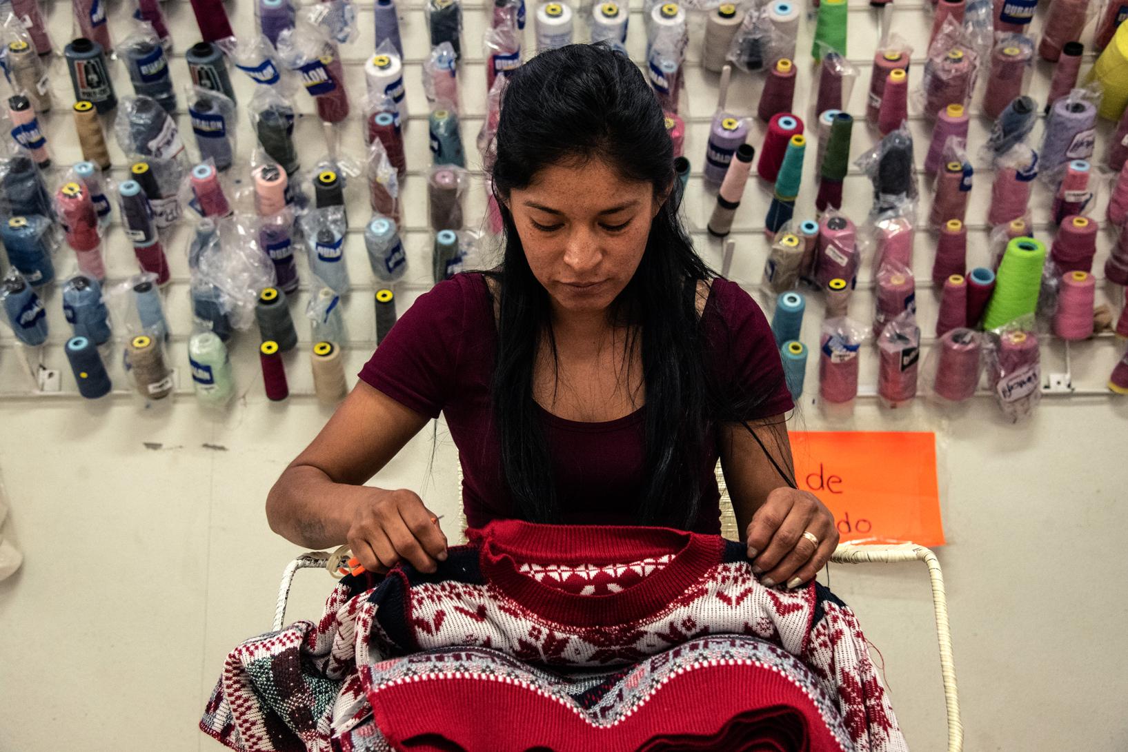 Una costurera observando un suéter que está maquilando