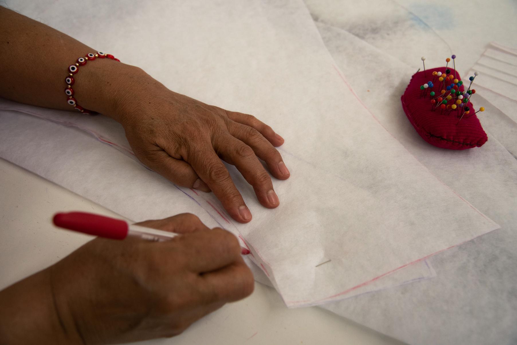 Una costurera tomando unas medidas sobre un lienzo